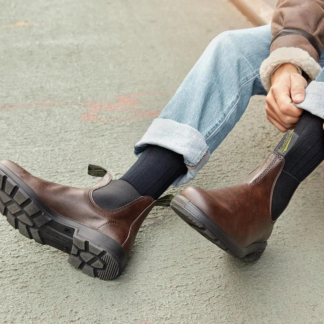 A child relaxes outdoors in blue jeans and Blundstone 2116 VEGAN Chelsea boots, brown with sturdy soles and easy pull-on sides. ksnz, 9315891528689, 9315891528702, 9315891528726, 9315891528740, 9315891528764, 9315891528788, 9315891528801, 9315891528825