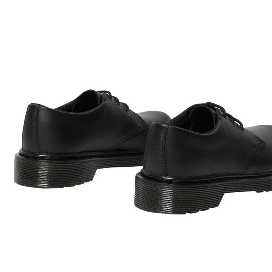 A pair of Dr. Martens kids 1461 Mono J black lace-up school shoes is shown from the back on a white background, featuring their thick, grooved soles and smooth leather finish., 20644, 20645, 190665364316, 190665364217, 20648, 190665364231, 20650, 19066536