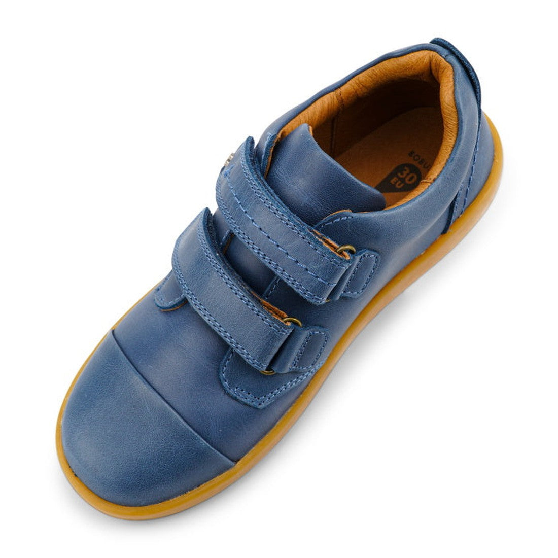 The Bobux Kid+ Port Shoe Midnight Blue 833007 is a children’s shoe with a blue leather upper, two Velcro straps, orange lining, and a light brown rubber sole, shown from above at a slight angle., 9420068525634, 9420068525641, 9420068525658, 9420068525665,