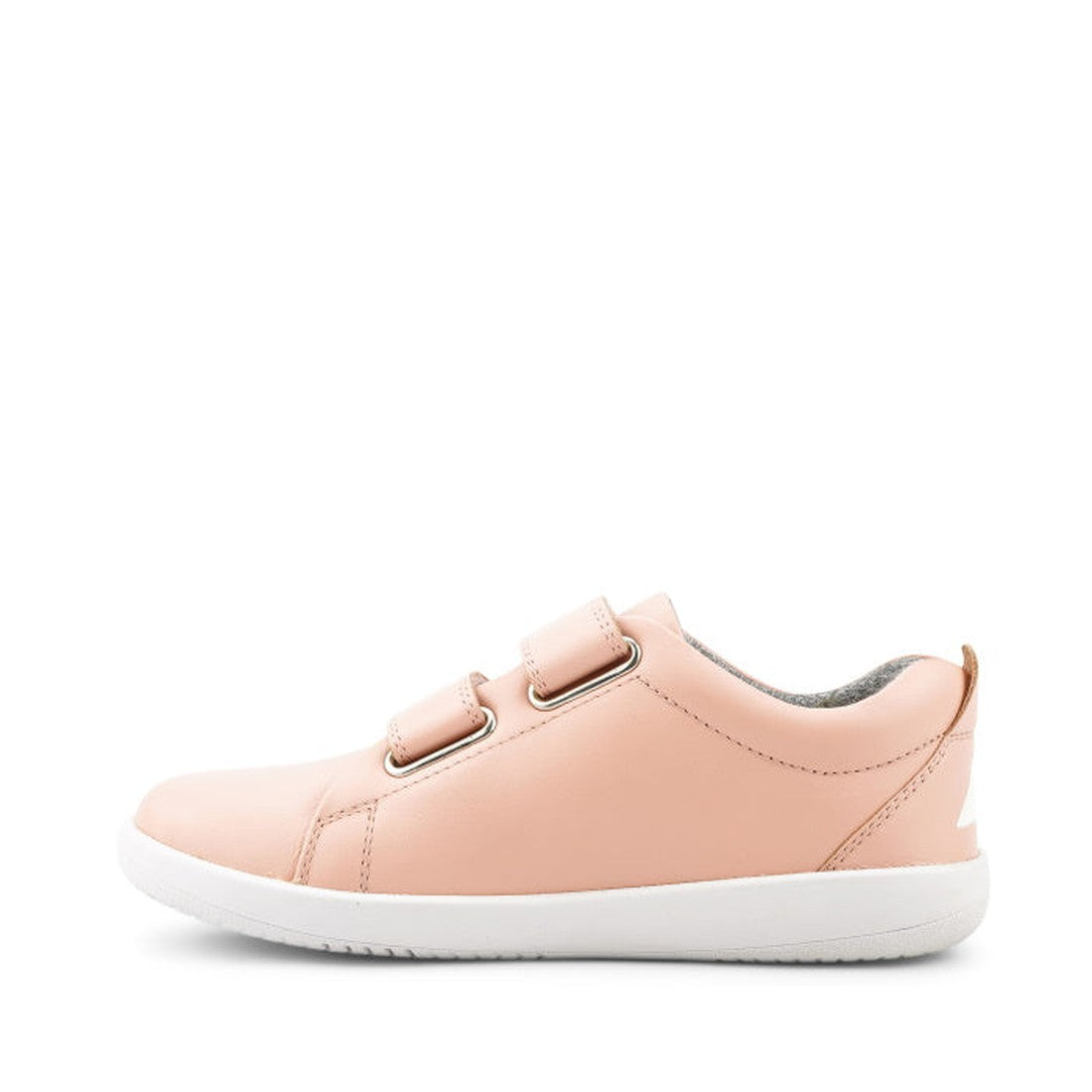 The Bobux Iwalk Grass Court Seashell Pink Leather Trainer features a light pink leather upper, two Velcro straps, and a white sole. Shown in a side view on a white background, these comfy kids’ sneakers are ideal for everyday wear., 9420062078877, 9420075