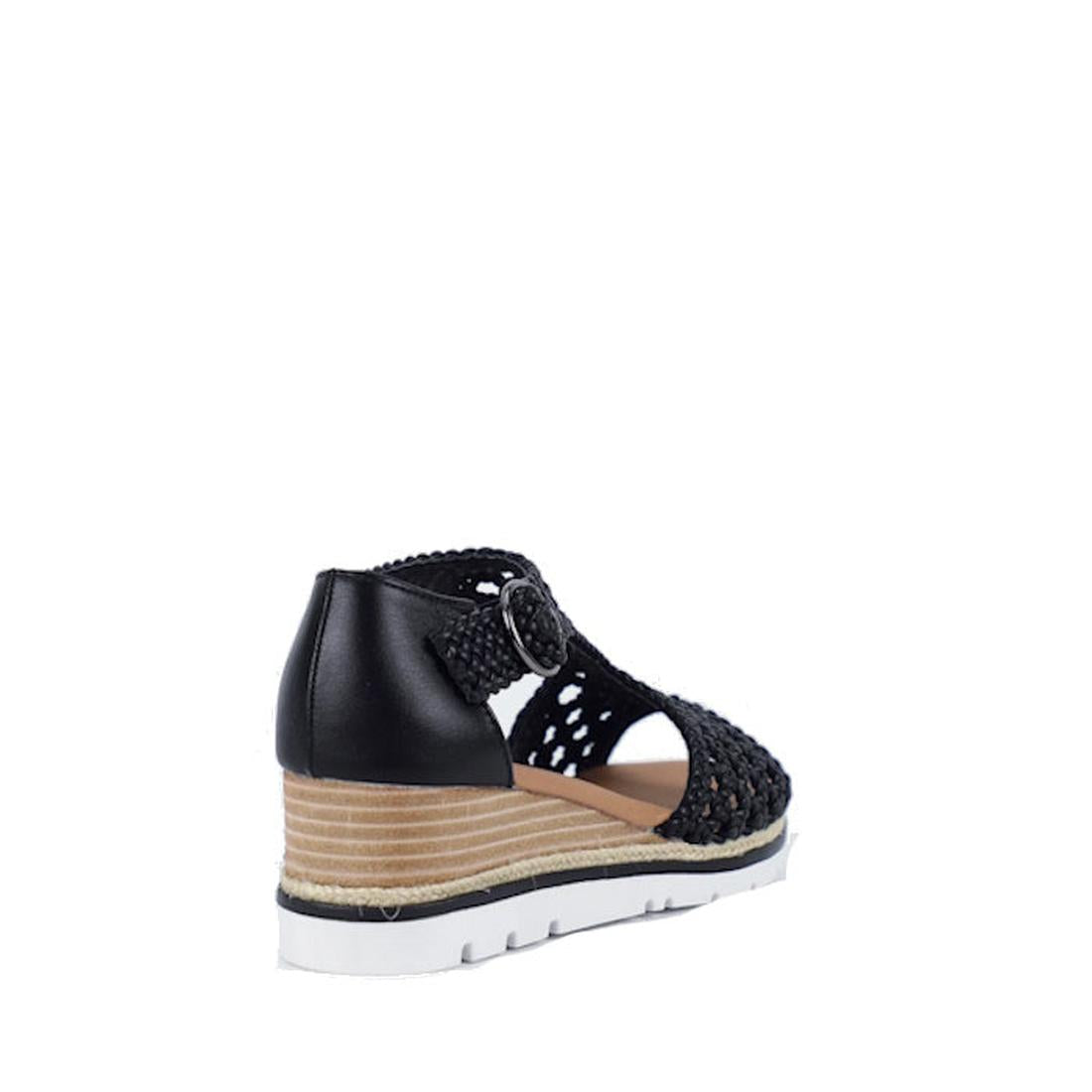 The Bay Lane Rumor Black Womens Woven Leather Wedge Sandal is shown from the back, featuring black woven leather, a closed heel, peep-toe front, adjustable side buckle, and a wedge sole with layered beige and white accents on a white background., 93576490