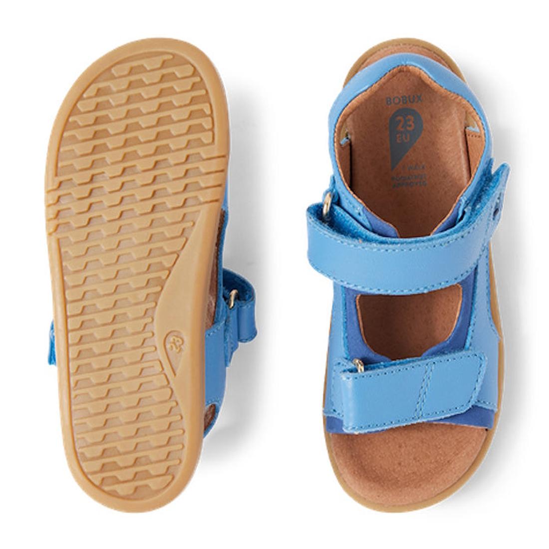 The Bobux IW Iwalk Strand Sandal in Azure Blue features tan rubber soles and open toes for toddlers. One sandal displays the tread, while the other highlights adjustable Velcro straps for a comfortable fit., 9420068556997, 9420068557000, 9420068557017, 94