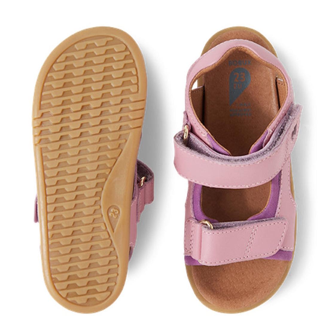 The Bobux IW Iwalk Strand Sandal in Lilas Pink is a toddler open-toe sandal with purple accents, adjustable Velcro straps, and tan rubber soles. One sandal is shown from the top; the other displays the sole's tread pattern., 9420068556942, 9420068556959, 