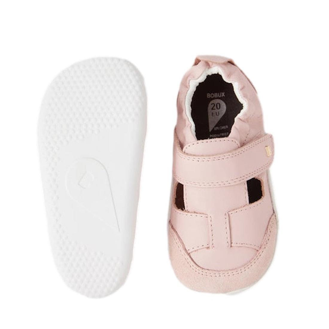 The Bobux XP Explorer Beau First Walker Sandal in Ballet Pink features premium leather, a closed toe, a front strap, white soles, and an elasticized ankle. One shoe is shown from the top and the other from the bottom., 48687, 9420068568969, 9420068568976,