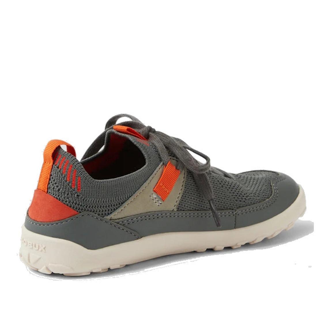 The Bobux Kid+ Meta Knit Barefoot Sneaker in Vetiver Green for juniors has orange and tan accents, a breathable knit upper, mesh detailing, a white textured sole, visible laces, and a heel pull tab. Shown angled on a white background., 9420074836014, 9420