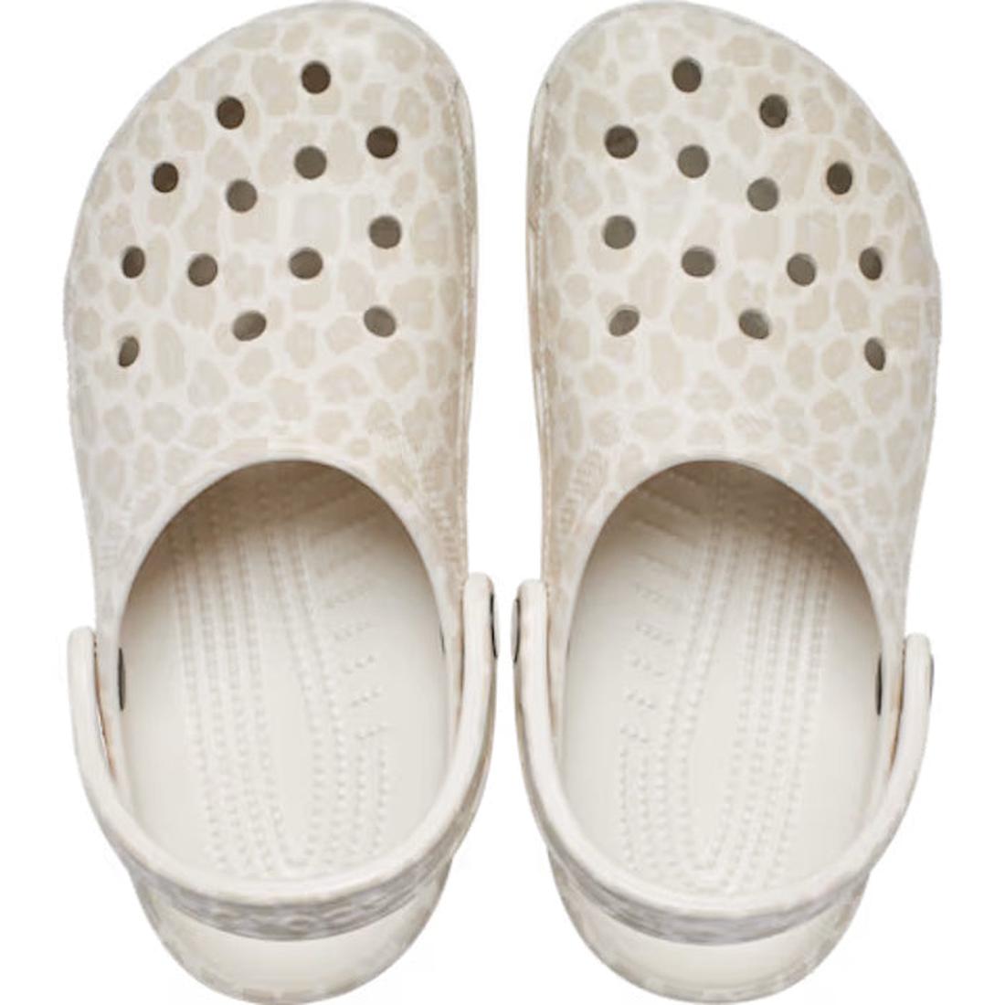 The Crocs Adults Classic Animal Clog in Almond Tint Leopard is a light beige clog with a leopard print, featuring top ventilation holes and adjustable heel straps for comfort. Viewed from above, its lightweight design stands out., 51497, 198445344978, 198