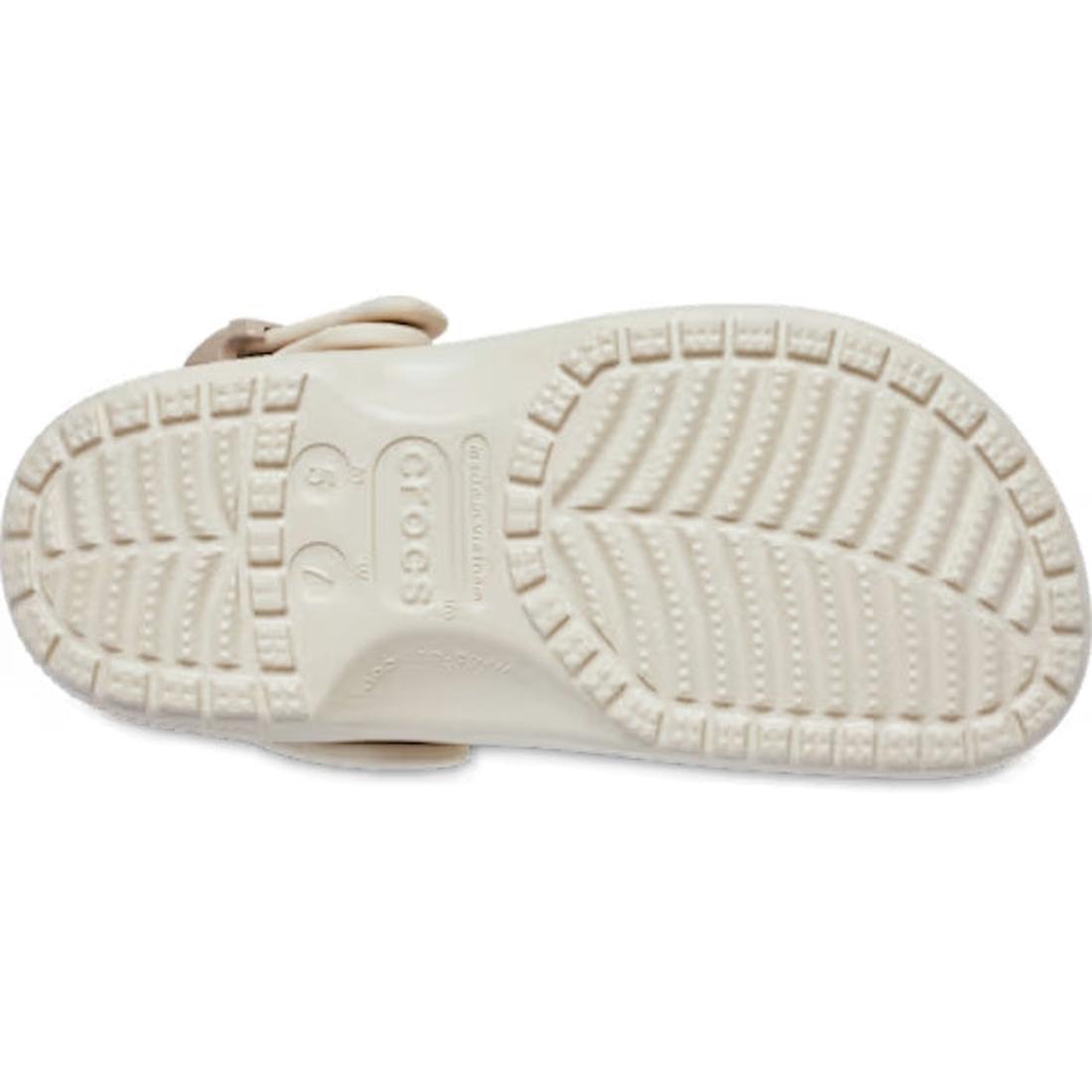 The image displays the sole of the Crocs Adults Classic Enamel Buckle Clog Frappe, a light-toned sandal with deep grooves, circular grip textures, and visible size and brand details. Crafted from Croslite foam for classic Crocs comfort., 198445415944, 198, 198445415951, 198445415968, 198445415975, 198445415982, 198445415999