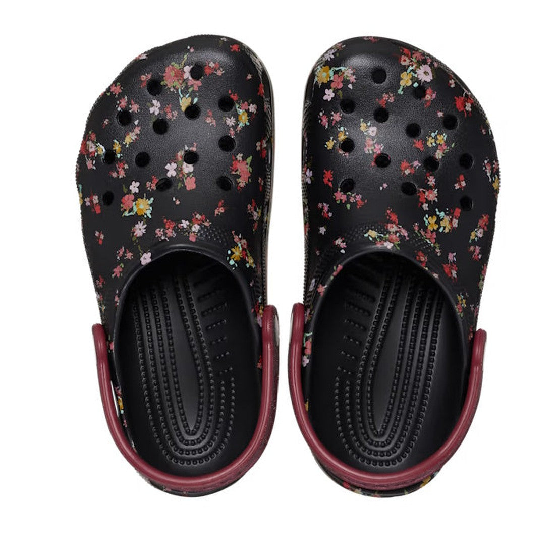 The Crocs Kids - Youths Classic Clog K Ditsy Floral Black Multi Sandal features black clogs for kids with colorful ditsy floral graphics and maroon heel straps, offering signature Crocs comfort, displayed from above., 196265775637, 196265775644, 196265775