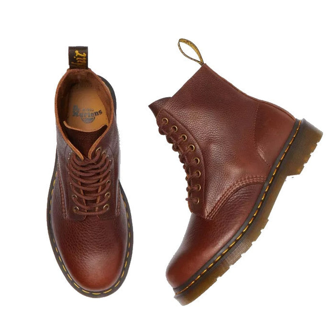 Flay lay of a pair of Dr Martens Cashew Ambassador leather boots. Showing the right foot top down and the left foot on the side. The pebbeld look of the leather is visable and the top of the boot cut off with no binding and the brass looking eyelets.,
190
