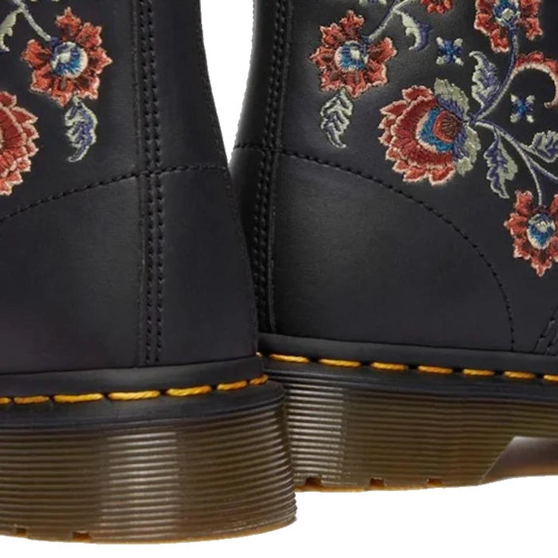 Close-up of the heels of two Dr Martens 1460 Vonda TF Tavern Floral Genix Nappa Leather boots, showing thick brown soles, yellow stitching, and colorful red, blue, and green embroidered floral designs., 47991, 190665742619, 190665742626, 190665742633, 190