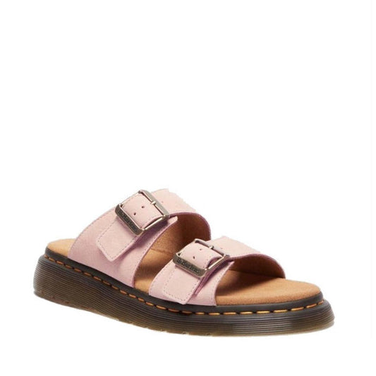 Shot of right foot from front and including outer side Pink Dr Martens Josef slide with 2 straps, both with buckles for adjustment and with brown sole and yellow stitching on a white background.