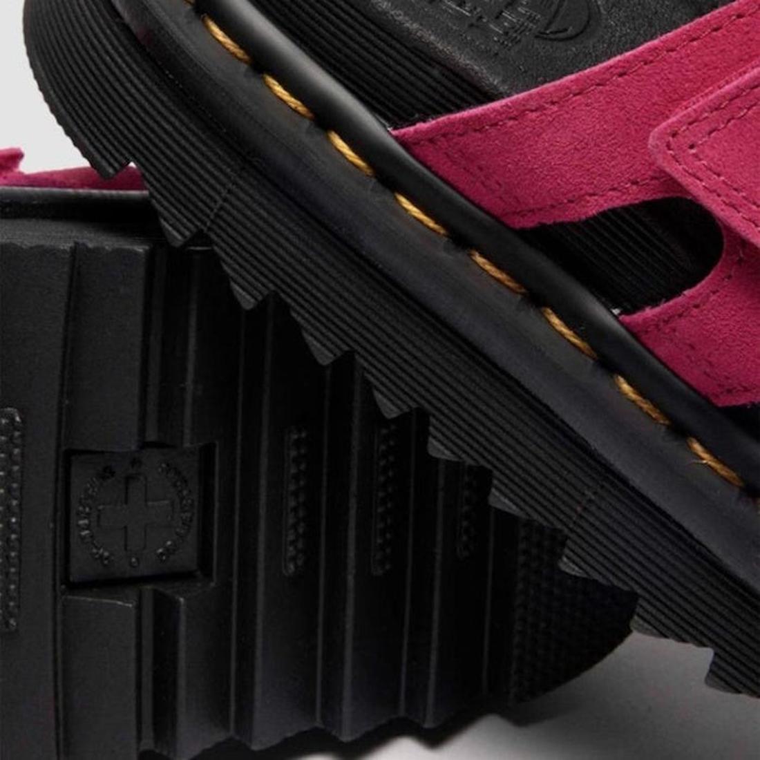 Close-up of Dr Martens Raine Fuchsia Pink Greasy Suede Leather Slides featuring black platform design, thick ridged EVA Zebrilus sole, bright pink straps, and visible yellow stitching along the edge., 47985, 190665750270, 190665750287, 190665750300, 47989
