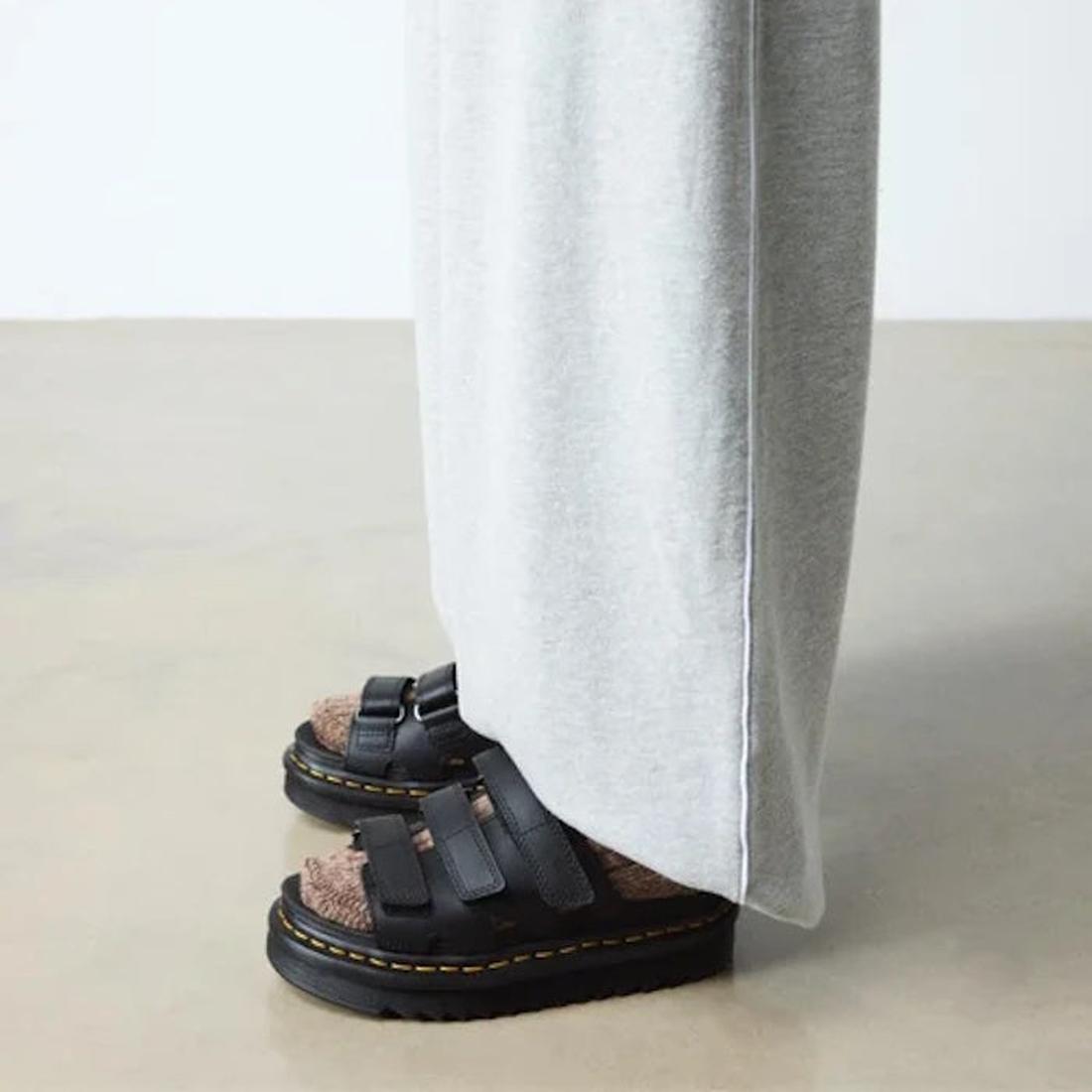 Black Dr Martens Raine sandals with 3 velcro straps worn by a person sitting on a white surface.
190665717761,
190665717778,
190665717785,
190665717808,
190665717815,
190665717822,, 41936, 190665717761, 190665717778, 190665717785, 190665717808, 1906657178