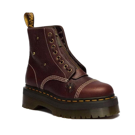 The Dr Martens Sinclair Flower Dark Brown Grizzly Leather Boot features floral designs, yellow stitching, metal eyelets, a front zipper, pull tab at the back, and a chunky Quad platform sole.