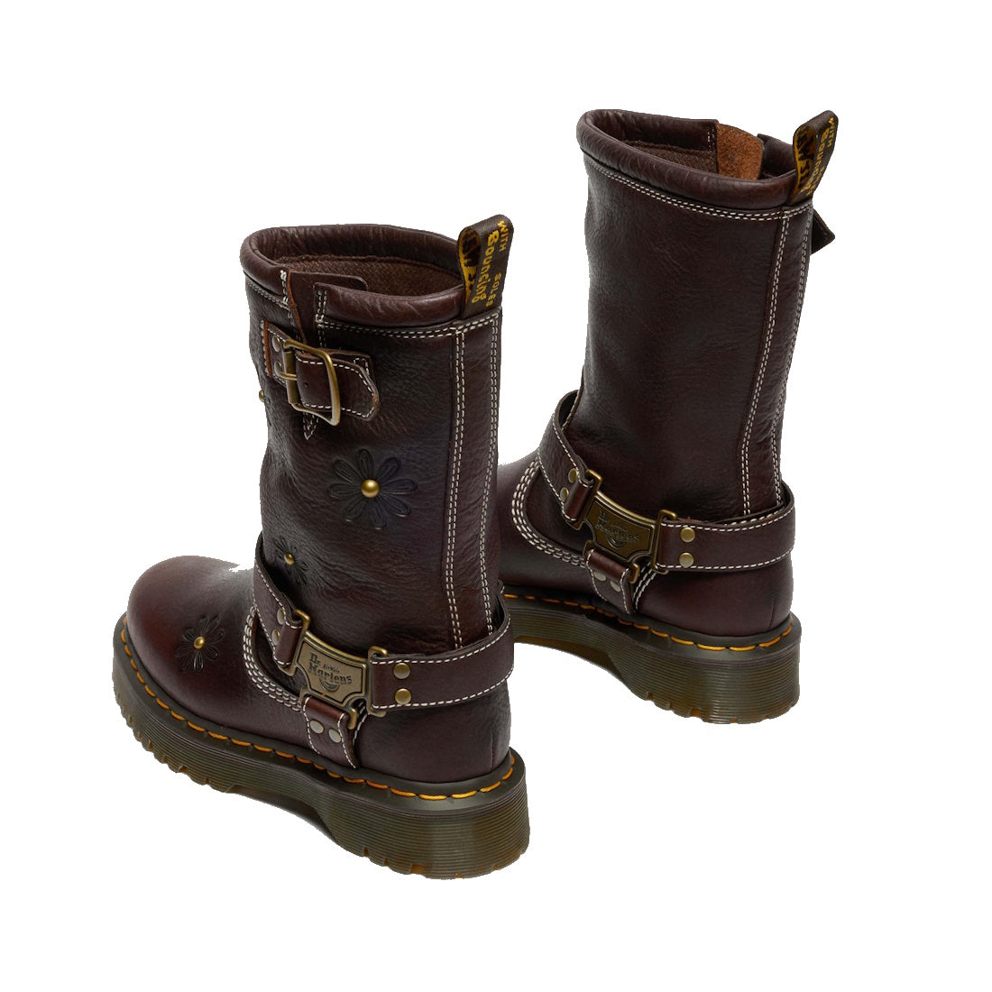 The Dr Martens Anistone Hi Flower Bex Grizzly Dark Brown boots feature floral detailing, decorative buckles, yellow stitching, thick soles, and rear pull tabs. These biker-inspired leather mid-calf boots are shown from an angled rear view., 52349, 1906657