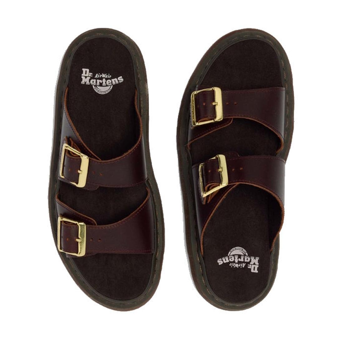 A pair of Dr Martens Josef Charro Atlas Slide Sandal Leather in dark brown with two gold-buckle straps, Goodyear-welted soles, and visible footbed logo, displayed on a white background., 52357, 190665783841, 190665783858, 190665783872, 190665783889, 19066