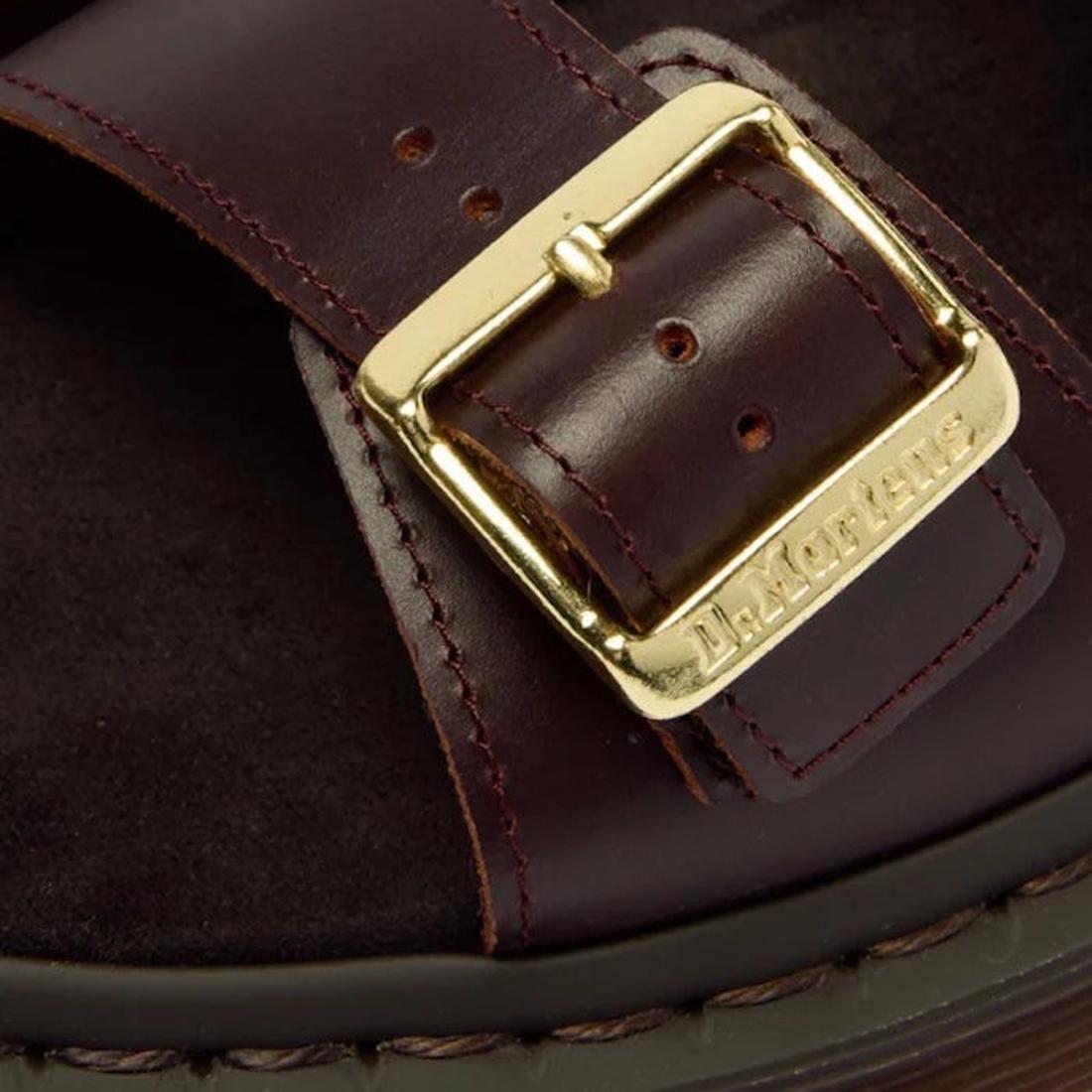 Close-up of the Dr Martens Josef Charro Atlas Slide Sandal Leather, featuring a brown leather strap with a gold buckle engraved with Dr. Martens, detailed stitching, and part of the black Goodyear-welted sole., 52357, 190665783841, 190665783858, 190665783