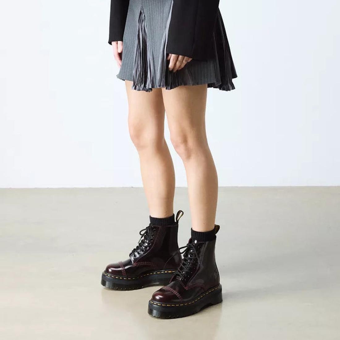 A person shows off the Dr Martens Sinclair Cherry Red Arcadia Leather Boots, featuring sturdy platform soles and easy zip-up closure.  ksnz, 51252, 190665278637, 190665278644, 190665278668, 51256
