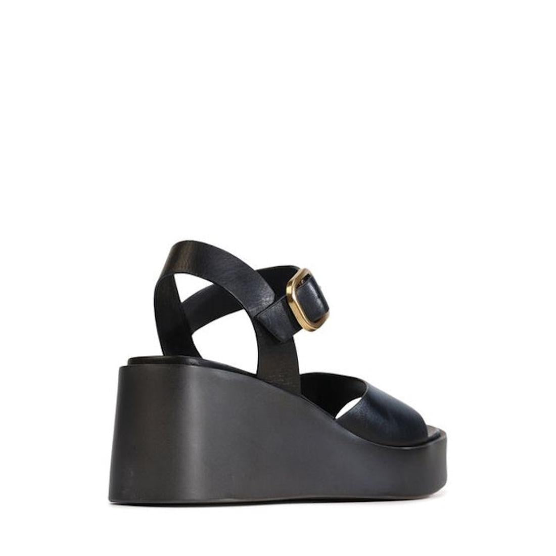 The EOS Ariya Black Leather Dressy Wedge Platform Sandal features a Y-frame design, wide front strap, crisscross ankle straps with a gold buckle, and is displayed against a plain white background., 47956, 9321191293714, 9321191293721, 9321191293738, 93211