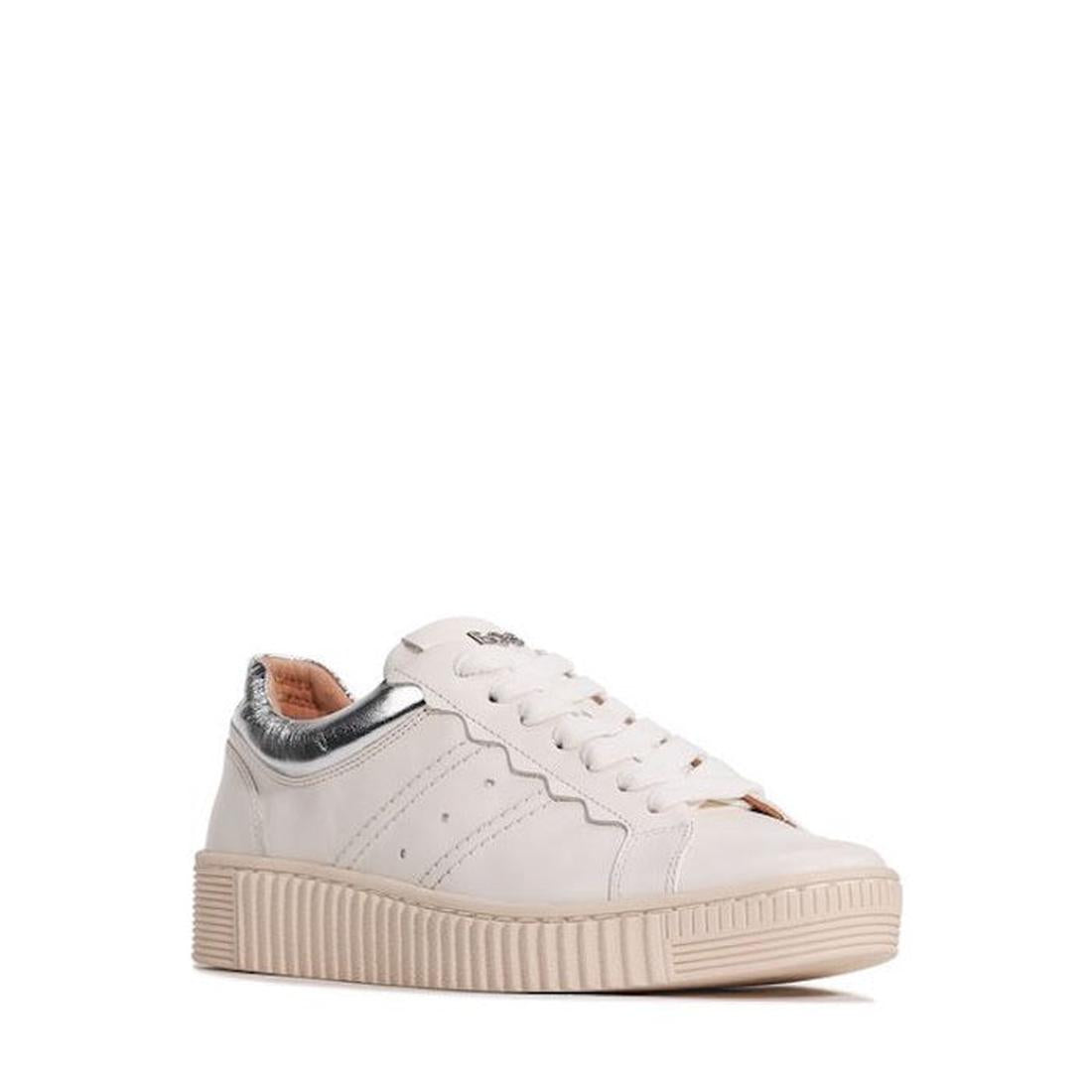 The EOS Jolie Bone Beige Women’s Leather Trainer features a thick beige sole, white laces, subtle side perforations, a metallic silver heel accent, and a side zip. Shown at an angle to highlight the side and front of this comfortable sneaker.