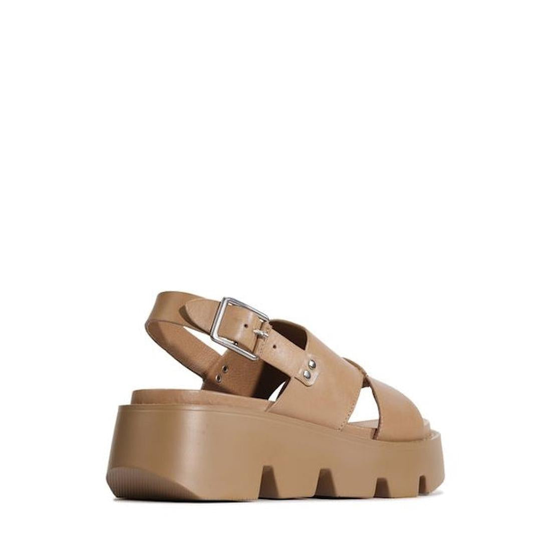 The EOS Kaily Womens Desert Leather Chunky Dressy Sandal features tan crisscross straps, a silver buckle, thick ridged wedge sole, and a back strap. Shown angled from the back on a white background, it effortlessly blends comfort and style., 47235, 932119