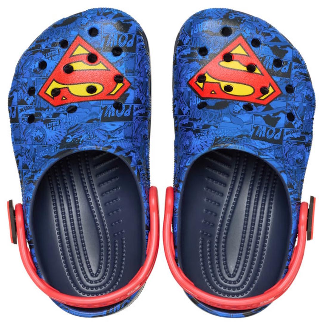 The Crocs Kids - Superman Classic Clog Blue in junior youths sizes features blue slip-on clogs with black comic-style patterns, red and yellow Superman logo on top, and red heel straps for a fun, heroic look., 198445182211, 198445182228, 198445182235, 198