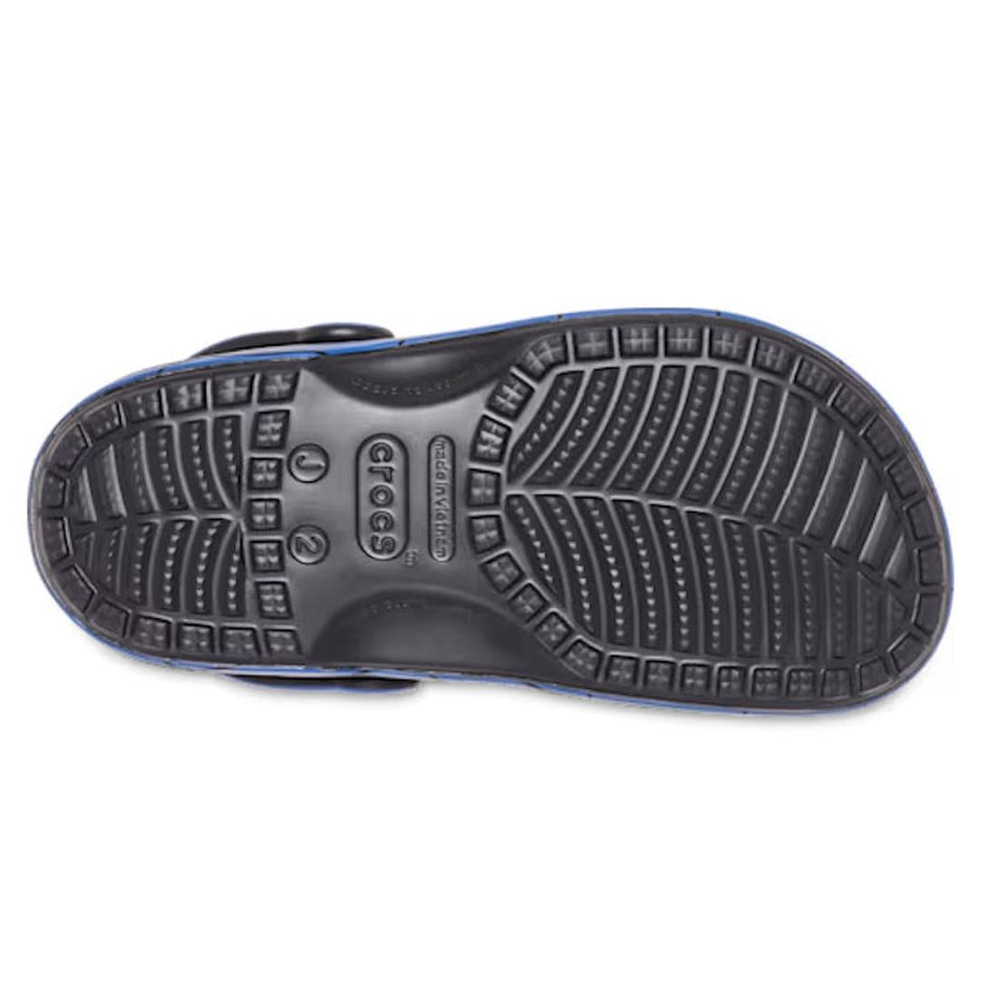The image shows the black textured sole of a Crocs Kids - Superman Classic Clog Blue (Junior Youths Sizes), viewed from the bottom. Geometric tread patterns provide grip, and the Crocs logo appears at the center of the heel area., 198445182211, 1984451822
