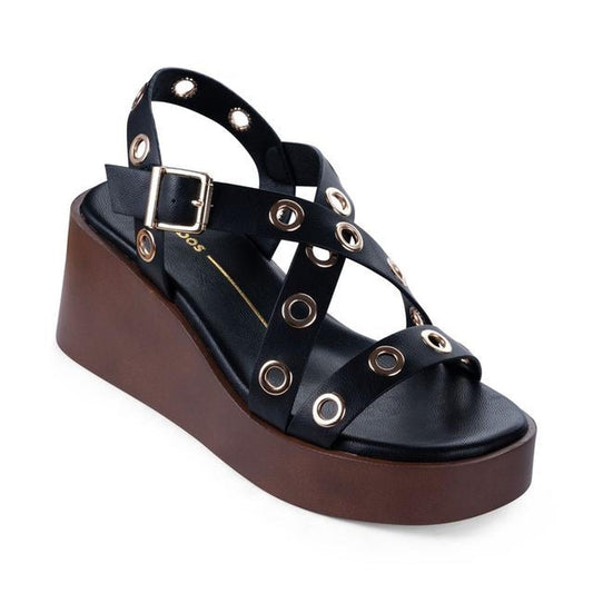 The Los Cabos Lagos Black Womens Wedge Heel Sandal features crisscross leather straps with large metal grommets, a side metal buckle, thick brown platform sole, and classic ankle strap styling.