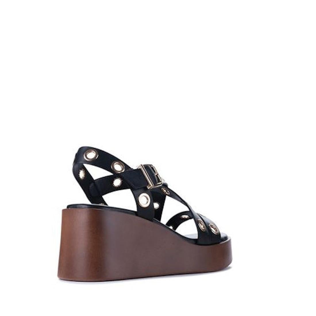 The Los Cabos Lagos Black Womens Wedge Heel Sandal, made from synthetic material, features ankle straps with metallic eyelets and a thick brown wedge heel. It's shown from the back-left side against a white background., 9321191309392, 9321191309408, 93211