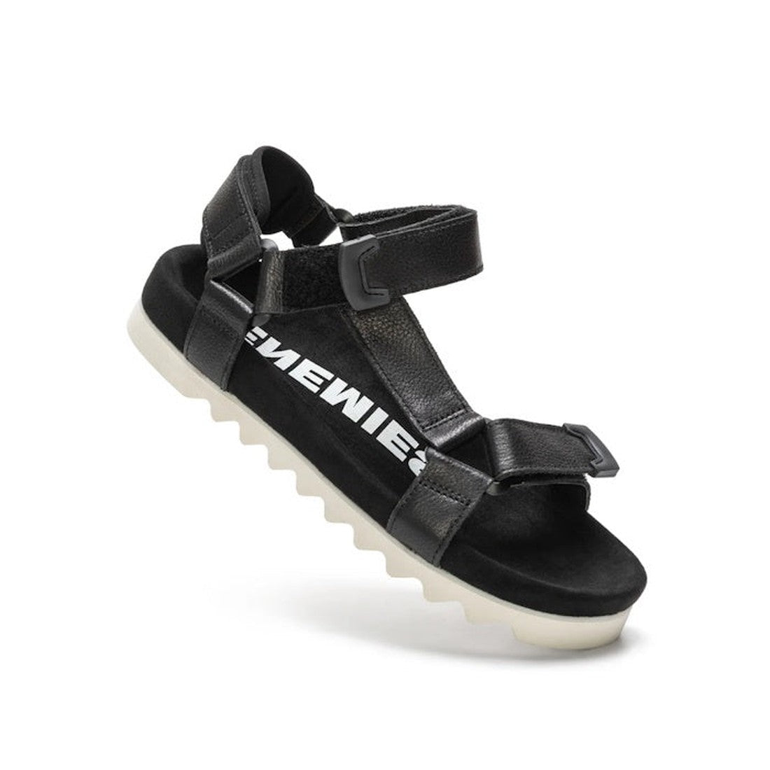 The Rollie Womens Sandal Tooth Wedge Black features adjustable black sheep leather straps, a white jagged EVA sawtooth outsole, and bold white EMEWIE text on the side.
