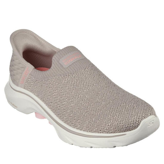 The Skechers Womens Slip In Go Walk 7 Springtime Taupe is a light taupe slip-on sneaker with a textured knit upper, white cushioned sole, subtle pink heel/logo accents, Hands Free Slip-ins for easy wear, and Air-Cooled Memory Foam for comfort.