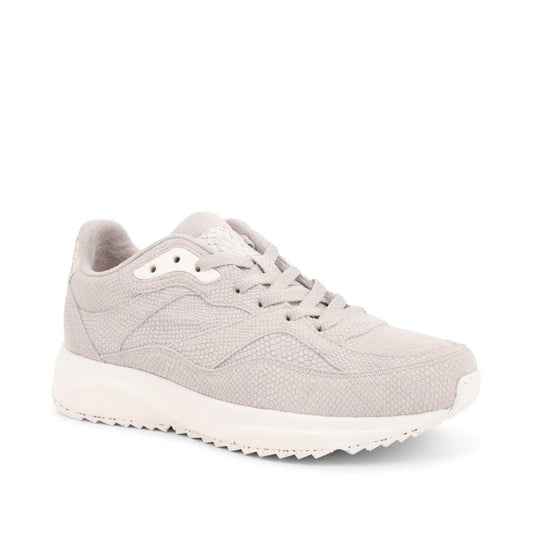 The Woden Sophie Snake Suede Sea Fog Grey Women's Sneaker features a light gray Scandinavian minimalist design with textured fabric, matching laces, and a white rubber sole as seen from the front angle.