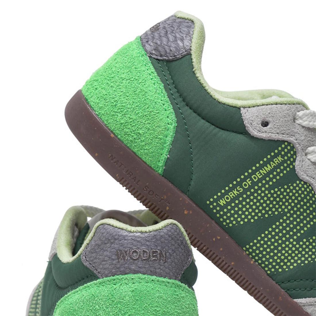 Close-up of Woden Nanna Apple Green Multi Lace Up Sneakers, featuring green tones with gray and light green accents, textured materials, WORKS OF DENMARK text on the side, WODEN on the heel, and a brown NATURAL SOFT sole., 50250, 5713326697834, 5713326697