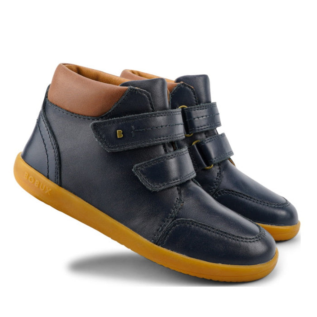 The Bobux Kid+ Timber Boot Navy 832905A is a pair of first walker boots with tan collars, yellow rubber soles, and double Velcro straps for fastening.