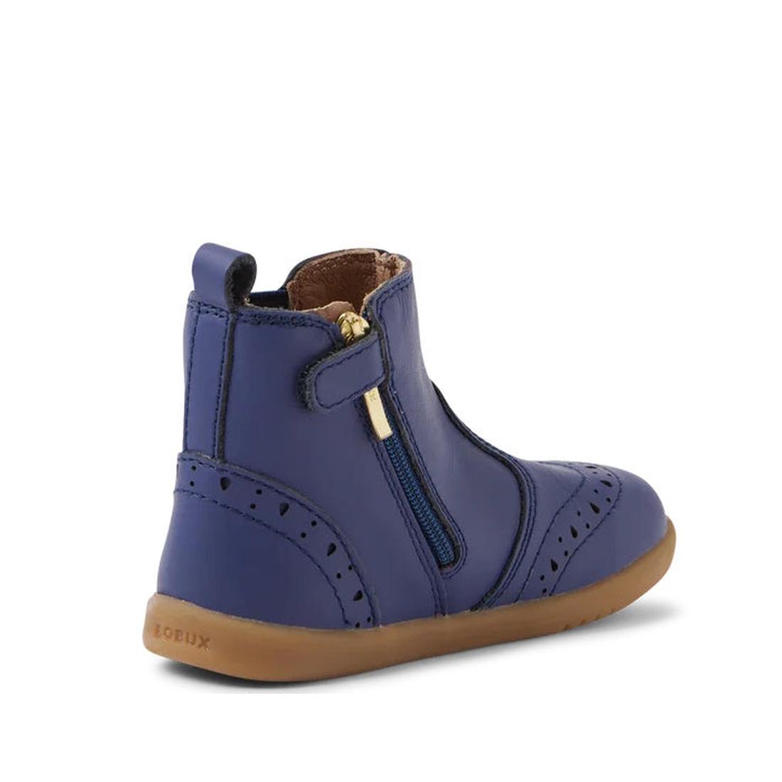 A single Bobux Iwalk Billie Toddlers Leather Boot in Future Dusk Blue/Purple (652002) with a tan rubber sole, brogue detailing, and a gold zipper closure, viewed from the back left. "Bobux" is embossed on the heel., 9420068543706,
9420068543713,
942006854