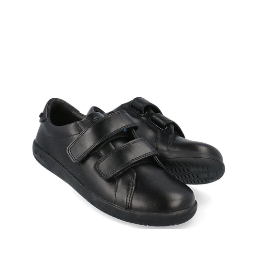The Bobux Kid+ Bound Black Leather School Sneaker Shoe is displayed against a white background, with one shoe upright and the other on its side to show the textured sole and dual adjustable straps.