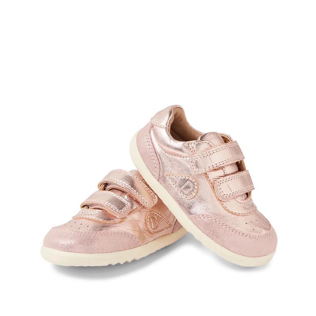 Bobux Step Up SU Champ Sneaker First Walker Rose Gold 750510—shiny rose gold leather baby sneakers with white soles and two Velcro straps, one leaning against the other on a white background.