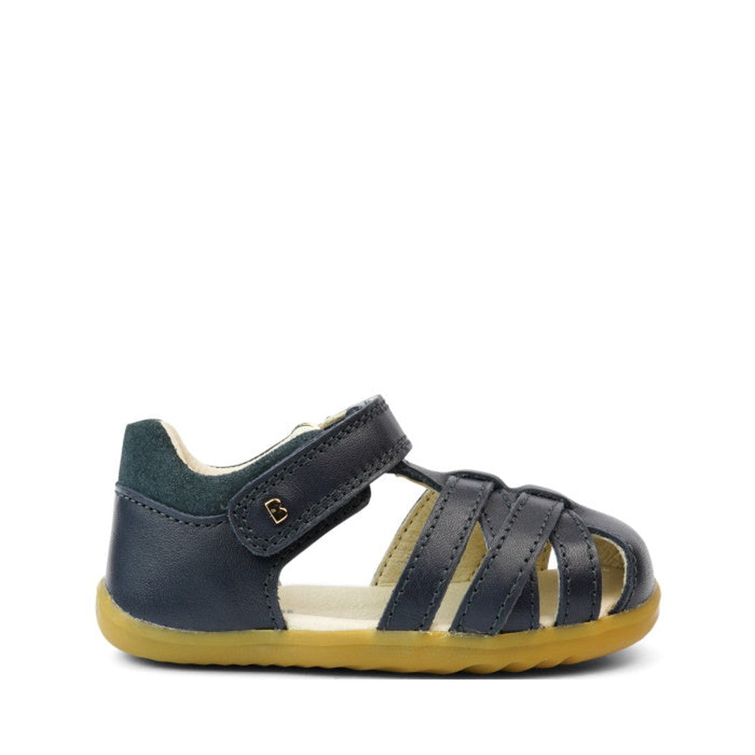 The Bobux Step Ups Cross Jump Navy Closed Toe Sandal is a unisex kids' sandal in navy leather with a closed heel, open toe, velcro strap, and flexible light brown sole—ideal as a first walker and shown on a white background., 9420062083567, 9420062083574,