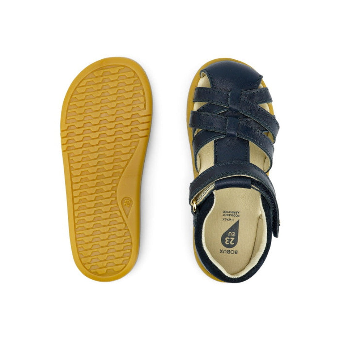 The Bobux iwalk Cross Jump Sandal Navy Closed Toe 636703 is shown: one sandal displays crisscross straps and a buckle from the top, the other highlights the tan textured sole from the bottom., 9420062083604, 9420062083611, 9420062083628, 9420062083635, 94