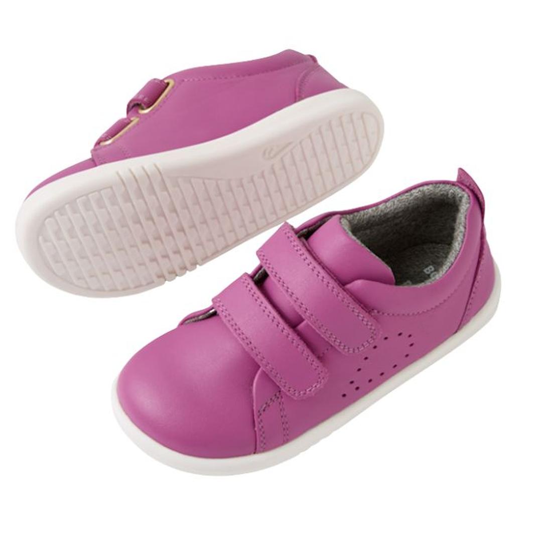 The Bobux IW Iwalk Grass Court Leather Sneaker in Cattleya Orchid Purple is a children's trainer with white soles, double strap closure, and side perforations for ventilation. One shoe is shown from the side, the other from the bottom., 9420074806987, 942