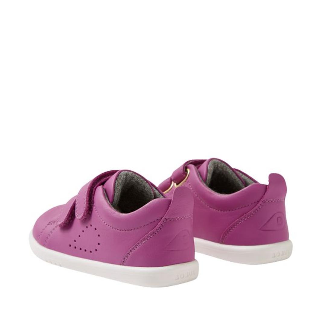 The Bobux IW Iwalk Grass Court Leather Sneaker in Cattleya Orchid Purple features white soles, double Velcro straps, and side perforations for toddlers, shown at an angle displaying both back and side views., 9420074806987, 9420074806994, 9420074807007, 9