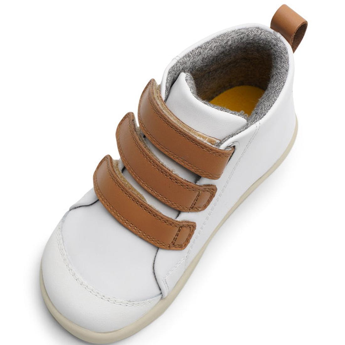 The Bobux IWalk IW Hi Court Boot White Caramel Clearance is a white children's sneaker with three brown velcro straps, tan heel pull tab, gray inner lining, and cream sole, made from premium coated leather and seen from above at an angle., 9420071319701, 
