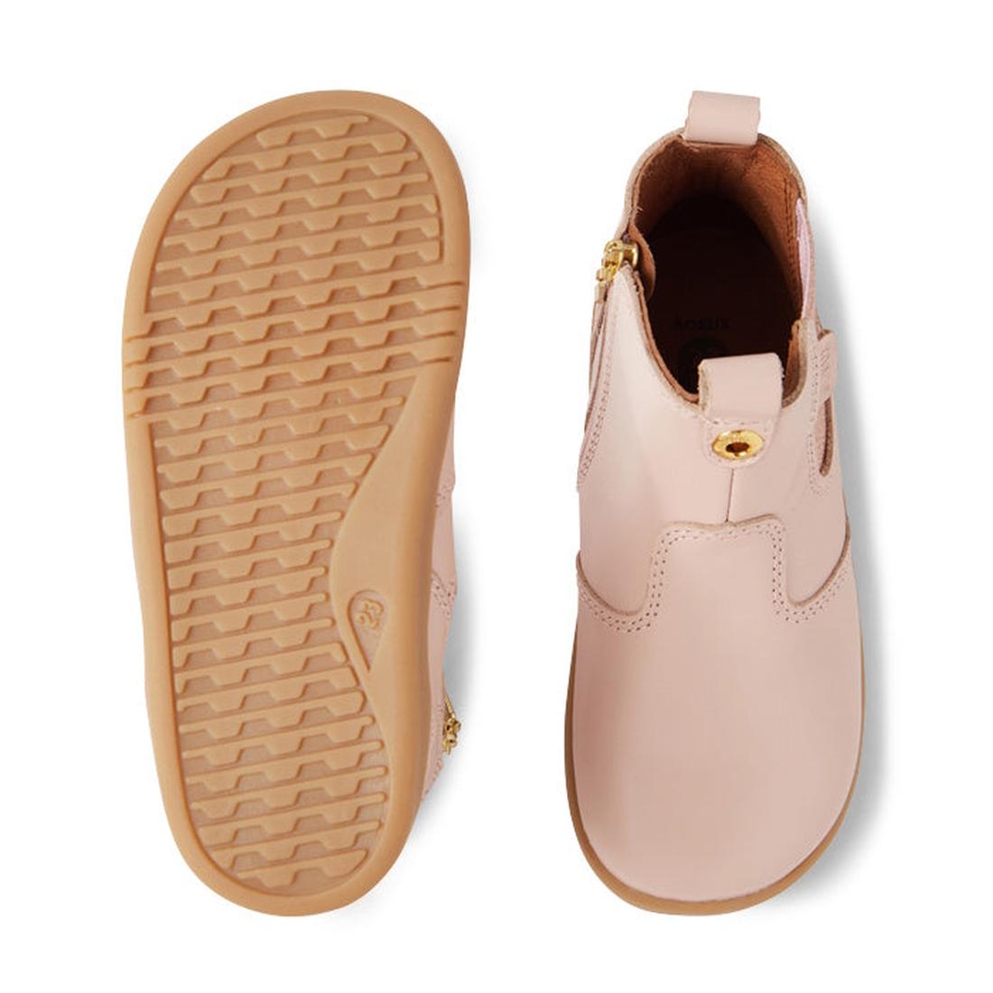 The Bobux IW Iwalk Jodhpur Leather Boot in Cameo Rose Pink is a podiatrist-endorsed toddler boot. One boot shows the tan textured rubber sole, while the other displays the top with a side zipper and elastic panel., 9420068539617, 9420068539624, 9420068539
