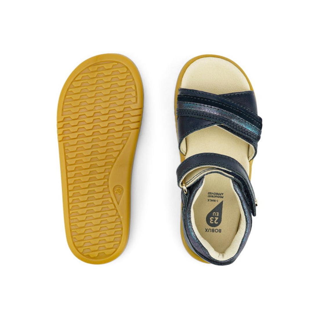 The Bobux iwalk IW Magic Girls Leather Sandal in navy features dark blue leather straps and yellow rubber soles; one sandal is shown from the top, the other from the bottom, revealing tread details and the shoe size label inside., 9420068522572, 942006852