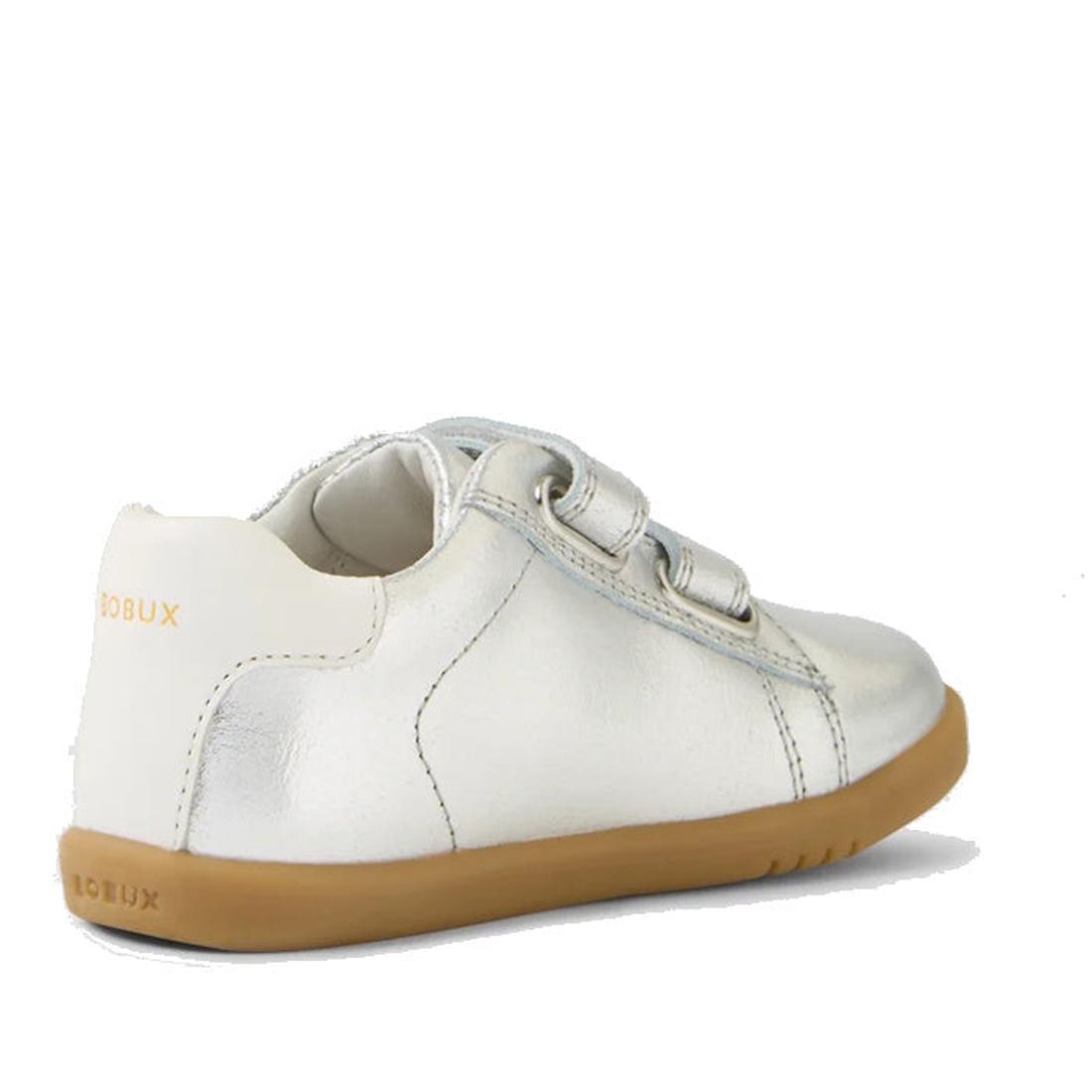 The Bobux IW Iwalk Maverick Leather Sneaker in metallic silver is shown from the back left, featuring beige laces, a light brown rubber sole, and the BOBUX logo on the heel. Crafted from breathable leather for kids' comfort against a white background., 94