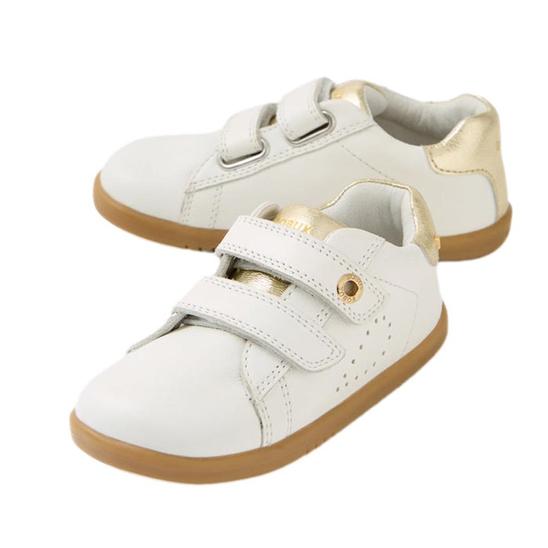 The Bobux IW Iwalk Maverick Leather Sneaker in White Gold features tan rubber soles, gold heel accents, and two adjustable straps for easy wear—perfect for toddlers.