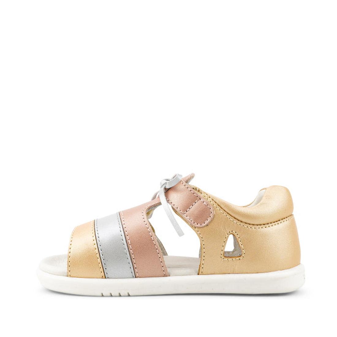 The Bobux IW Iwalk Mirror Pale Gold 633433 is a girls' open-toe sandal with gold, pink, and silver straps, gray laces, a white sole, and a side cut-out. Shown from the side against a white background., 9420068524088, 9420068524095, 9420068524101, 94200685