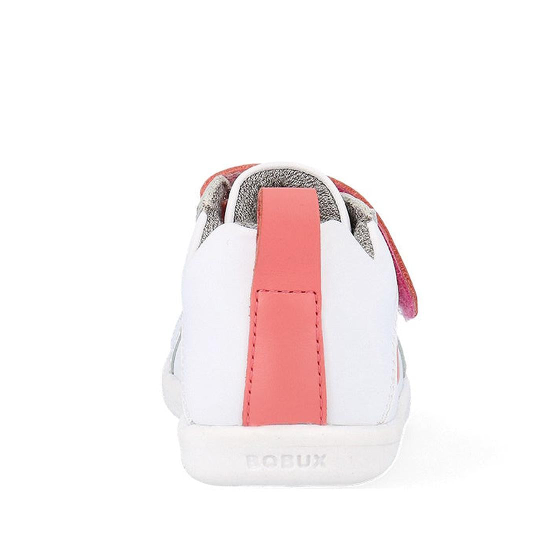 Back view of the Bobux Kids IWalk IW Pace Sneaker in White Coral (650402), featuring a white leather design with a pink vertical stripe and pink Velcro strap. The BOBUX logo is embossed on the sole. Unisex sporty shoe on a plain white background., 9420075