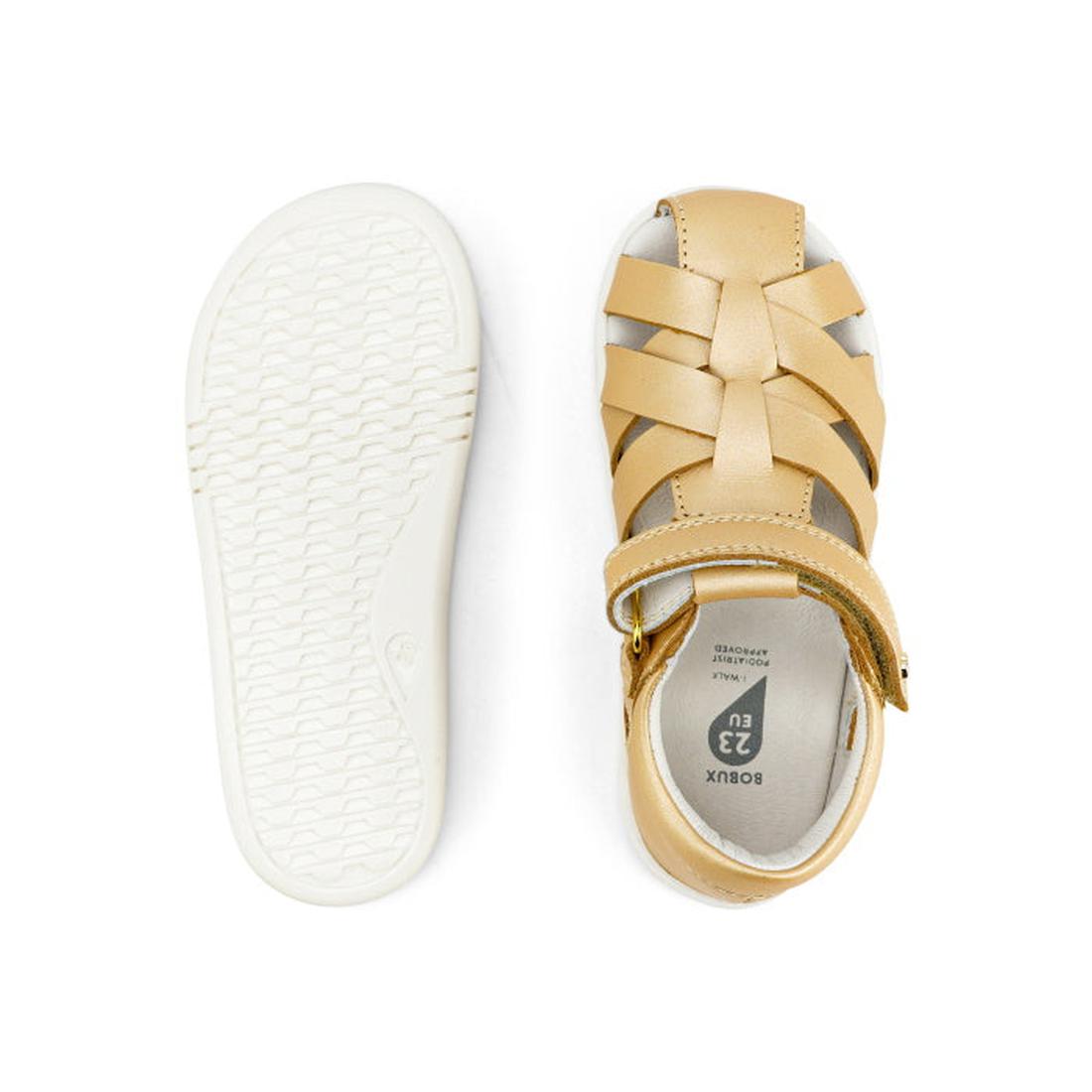 A pair of Bobux Iwalk IW Tropicana II Sandal 638311 in Pale Gold for children, shown from top and bottom, featuring a closed toe, woven Quick Dry Leather straps, hook-and-loop closure, and a white textured rubber sole., 9420068529946, 9420068529953, 94200