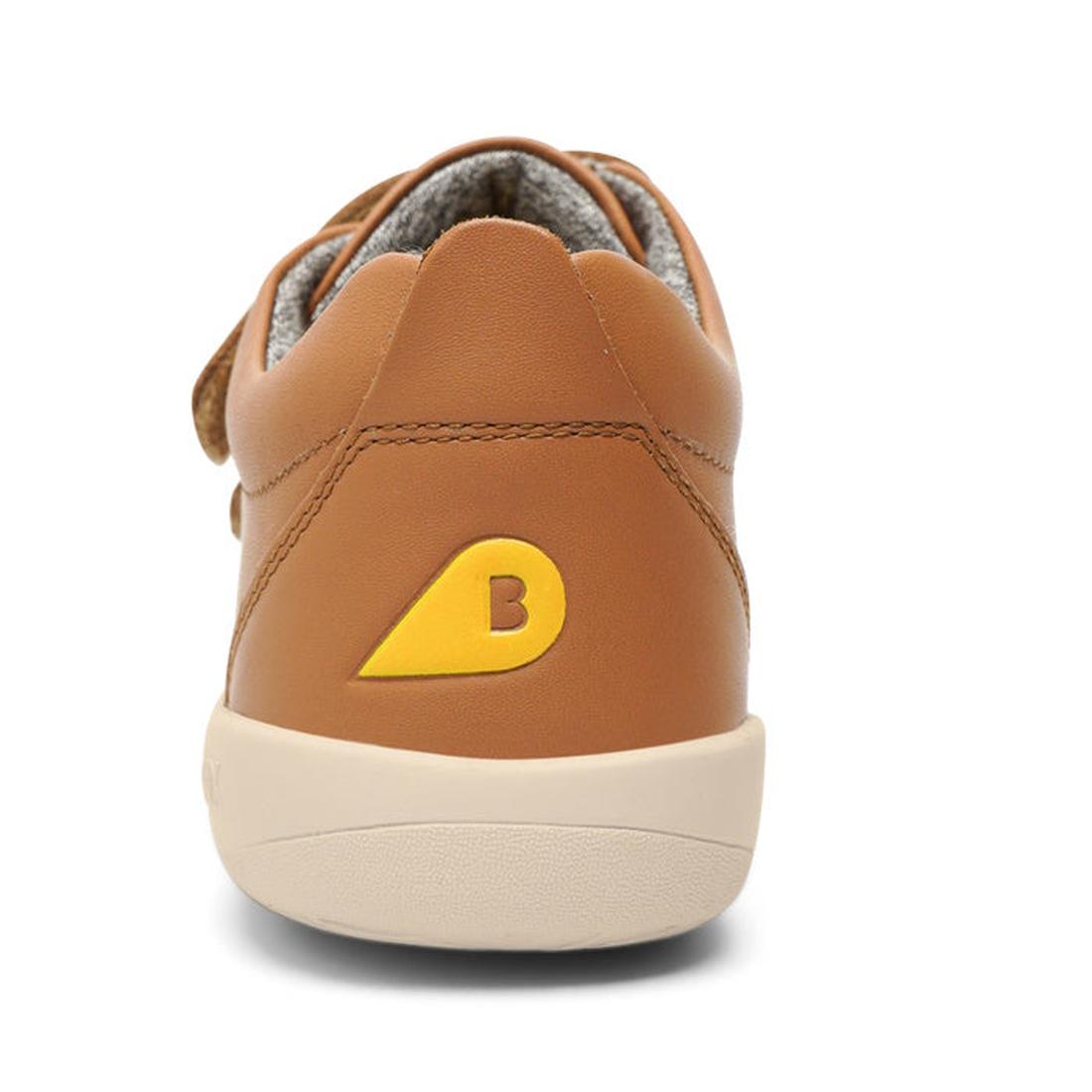 The Bobux Kids + Plus Grass Court Caramel Tan Velcro Trainers (832462) feature a brown leather design, a yellow and orange "B" logo on the heel, a light beige sole, and a wide opening for easy wear., 9420075792791, 9420071315963, 9420071315970, 9420071315